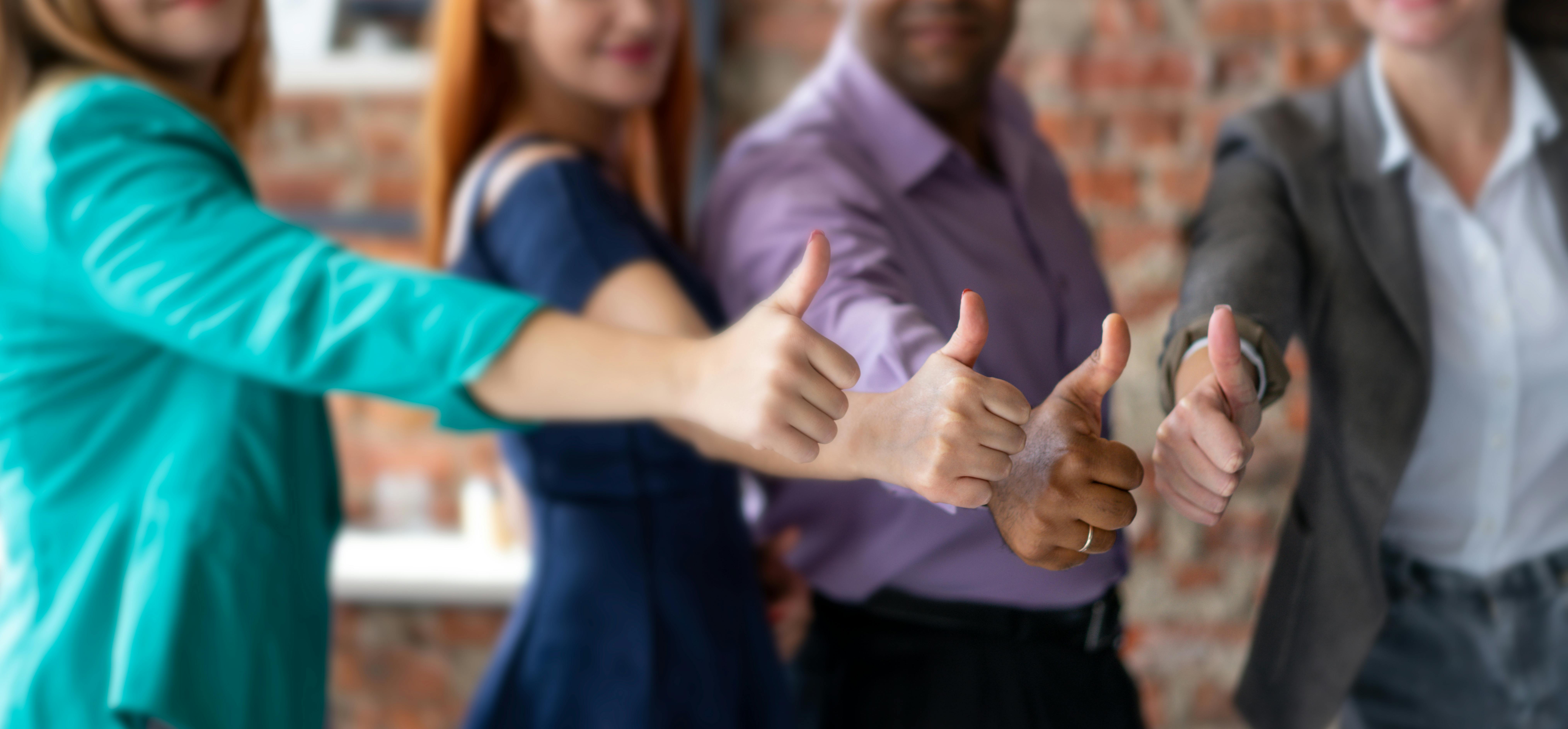 Typical Stock Photo showing a line of people with their thumbs up